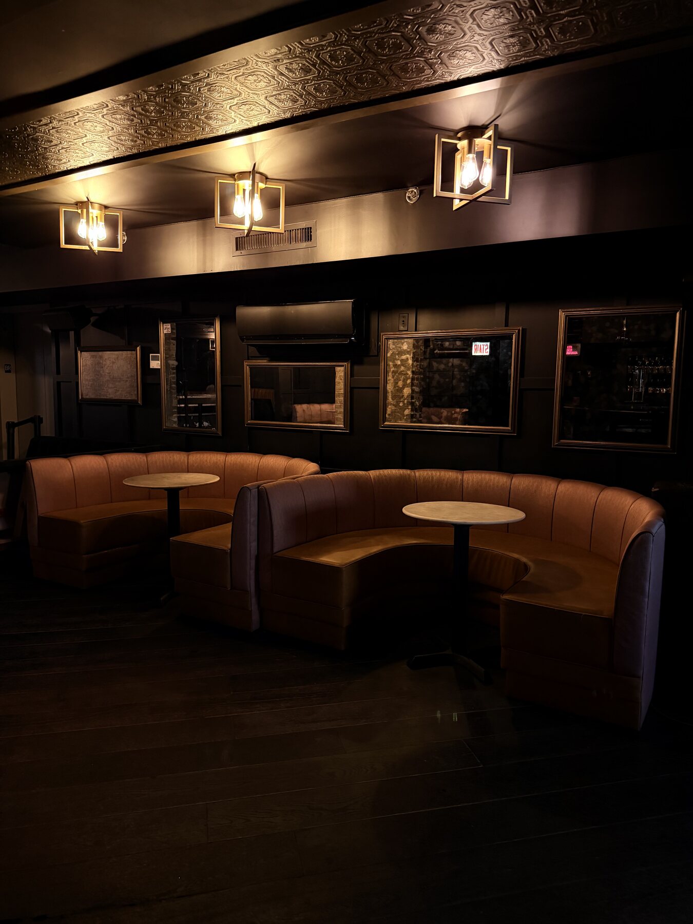 Curved banquette seating beneath warm pendant lights
